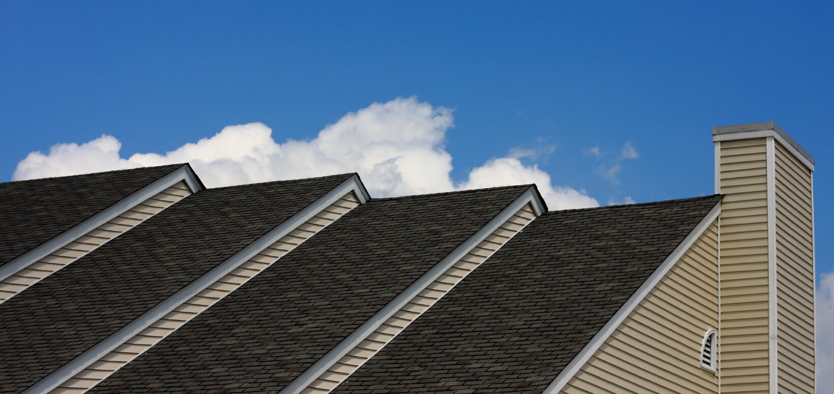 Finished shingle roof against a blue Florida sky